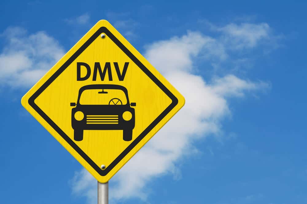 yellow road sign that reads DMV