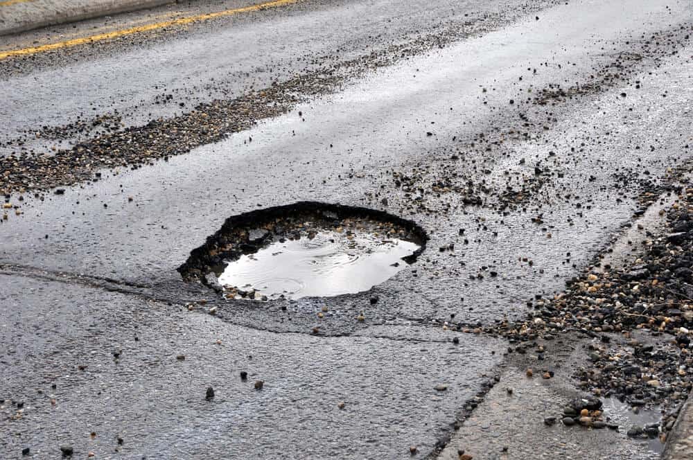 pothole with water on the road how to avoid them