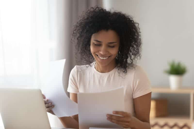 happy african american woman looking at car insurance policy