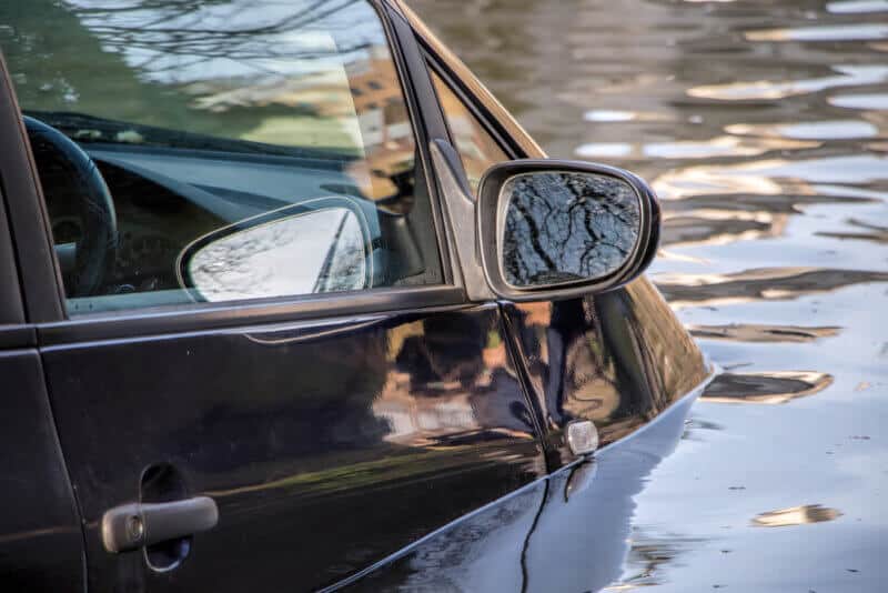 close up of car submerged in water during severe flood