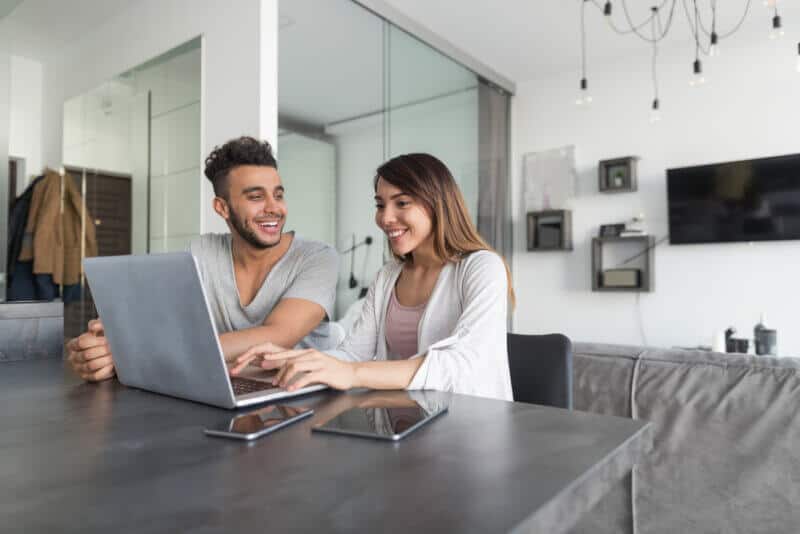 couple in table with laptop looking at how much is car insurance