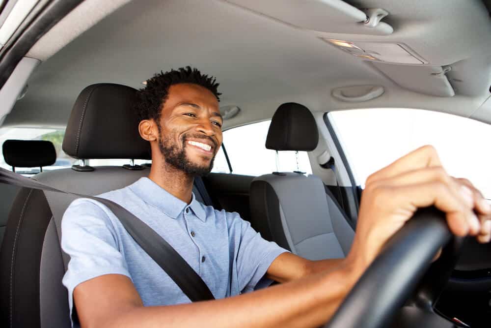 smiling african american man driving a car