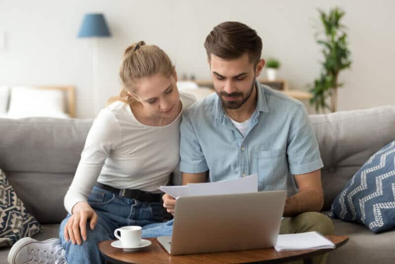 couple in couch looking at renters insurance paper in alabama