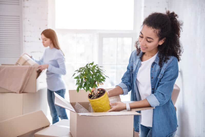 roommates unpacking boxes in new apartment