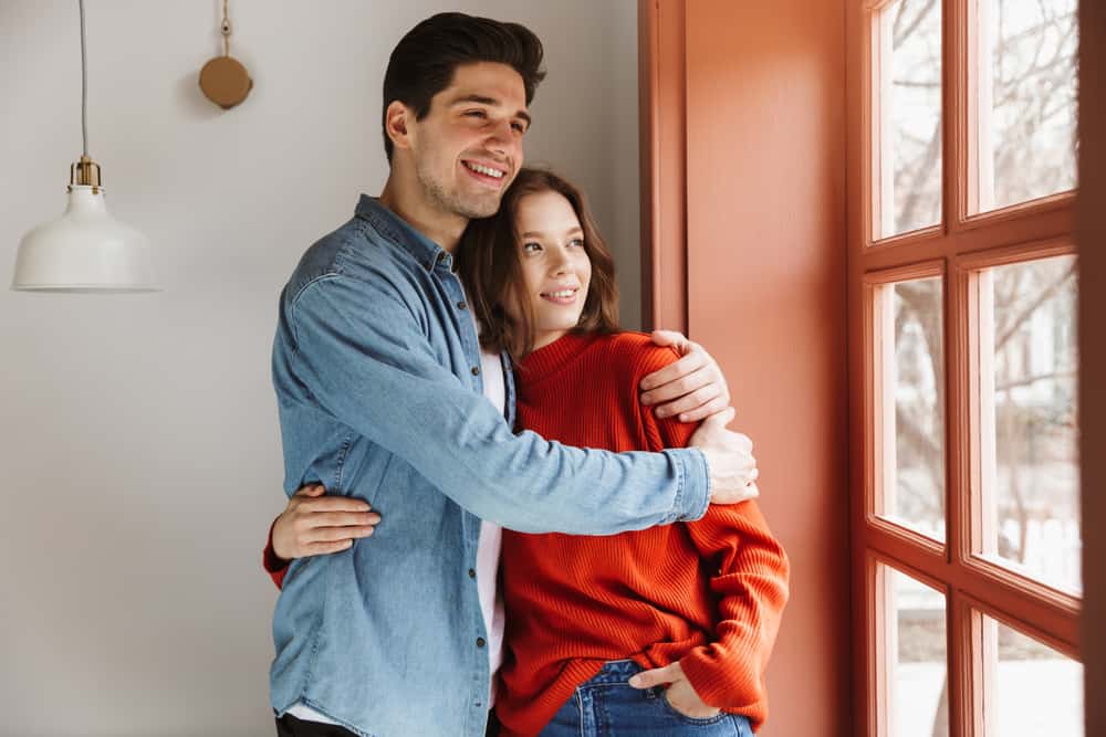 Young couple looking happily out window