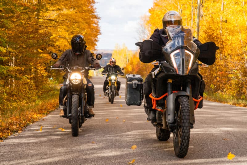 group of motorcyclists on fall road