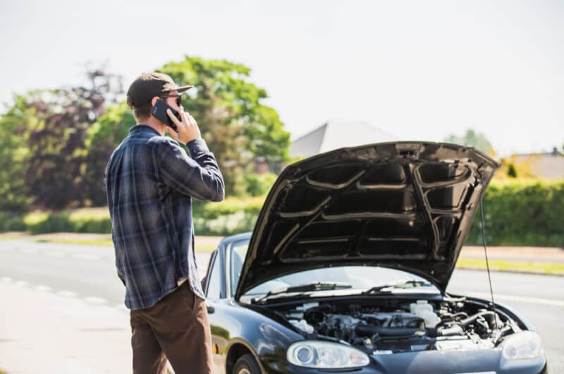 man next to car broken down on road